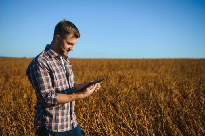 Farmer in a field holding a tablet